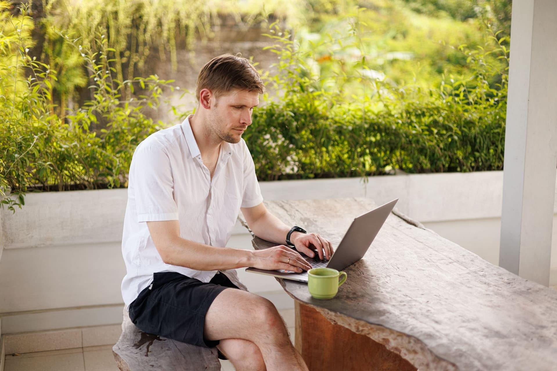 Selbstständiger Unternehmer arbeitet auf seiner Terrasse am Laptop